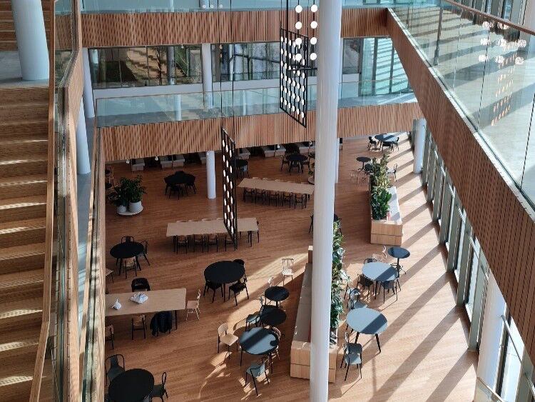 Atrium met zitgroepen en houten bekleding vanaf bovenaf gezien
